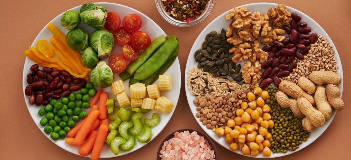 Vibrant display of assorted vegetables, legumes, nuts, and seeds on plates, perfect for healthy eating images.