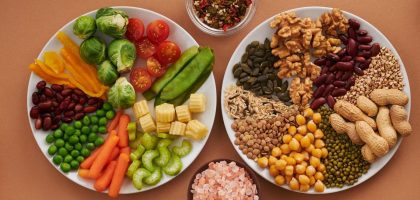 Vibrant display of assorted vegetables, legumes, nuts, and seeds on plates, perfect for healthy eating images.